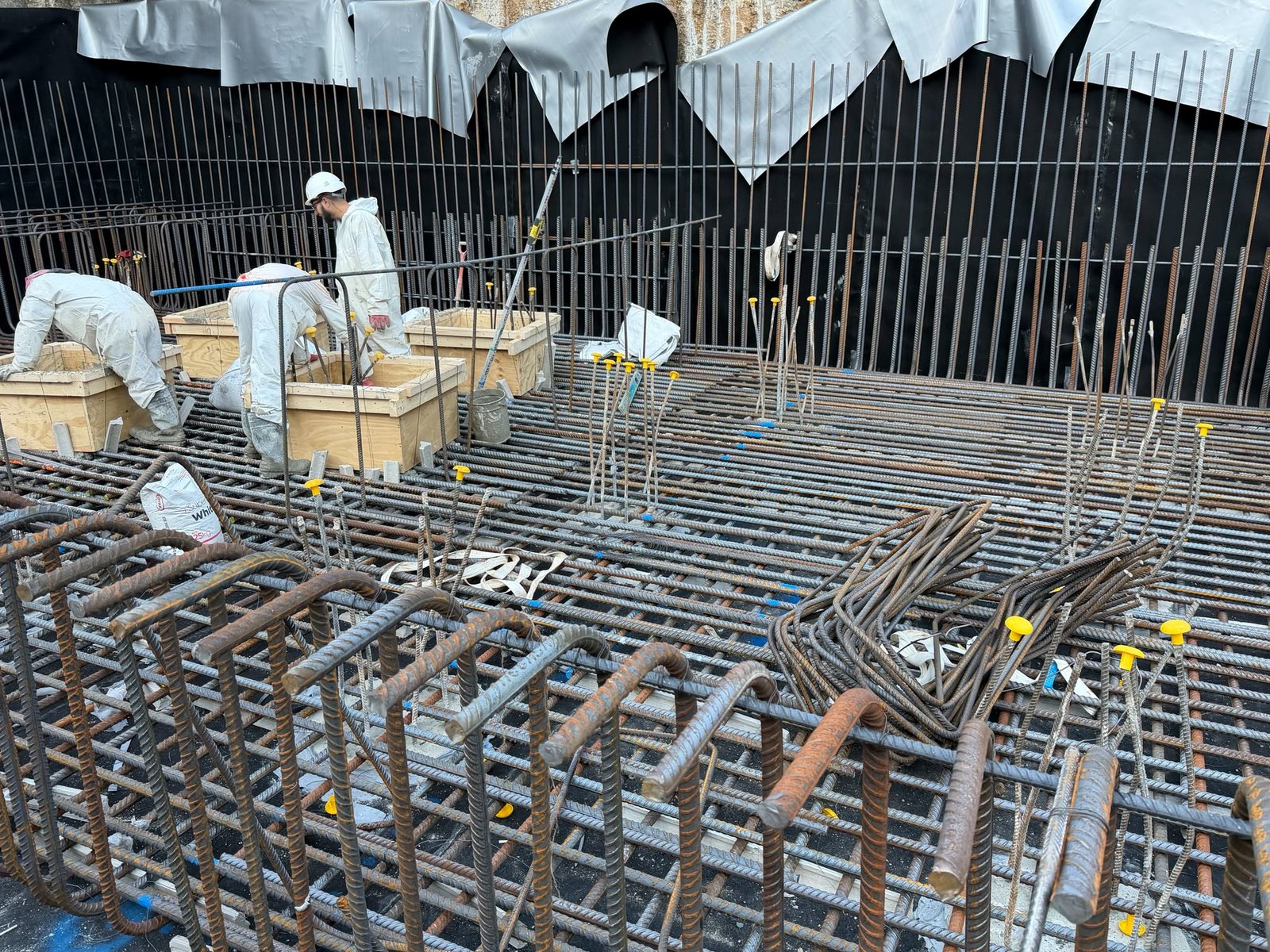Steel fixers tying a large slab reinforcement deck on a construction site
