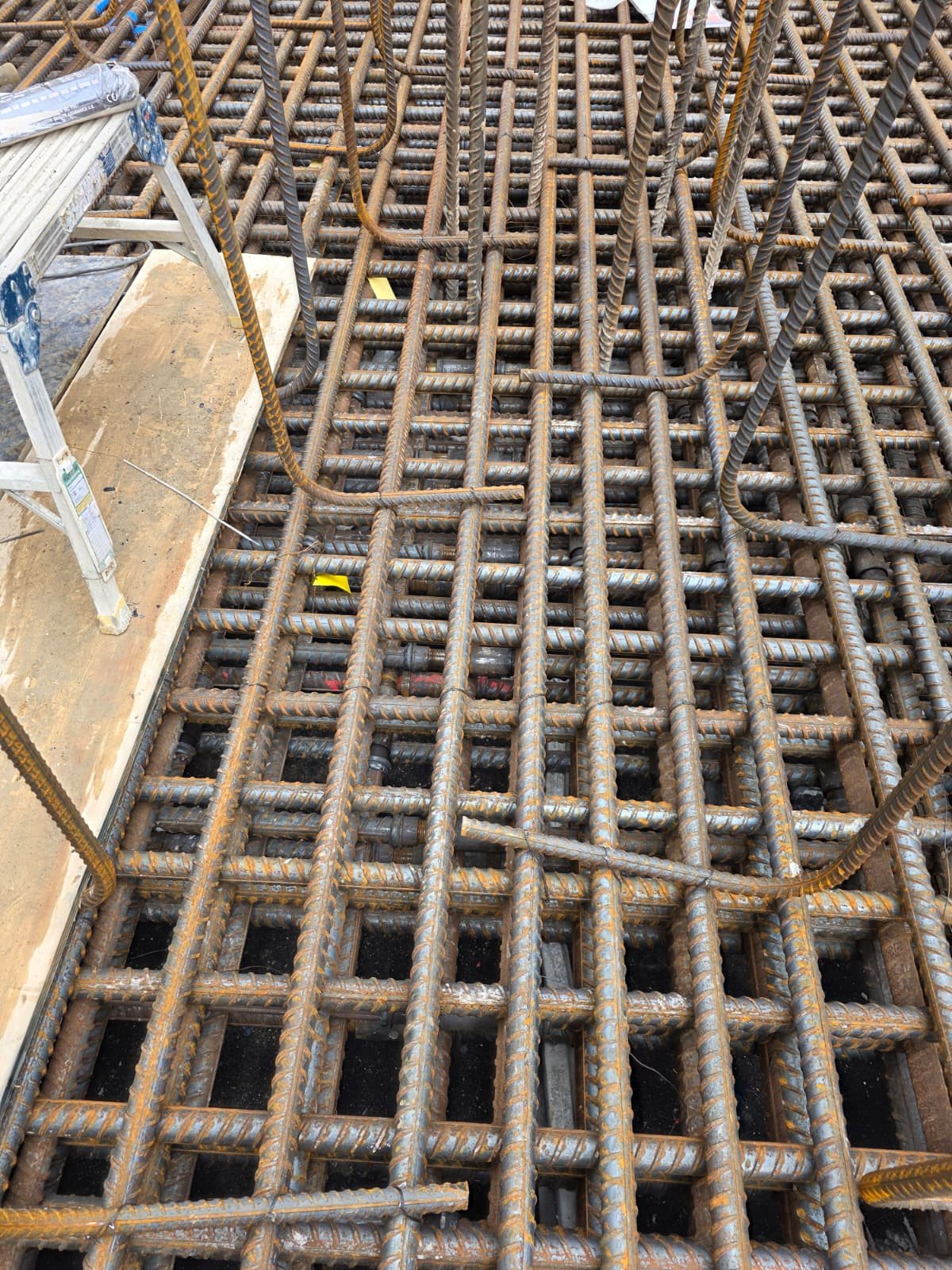 Layered rebar mesh mats stacked on site